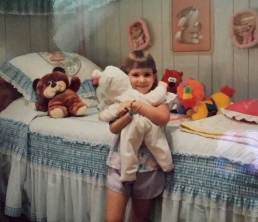 little girl with one arm holding a stuffed animal