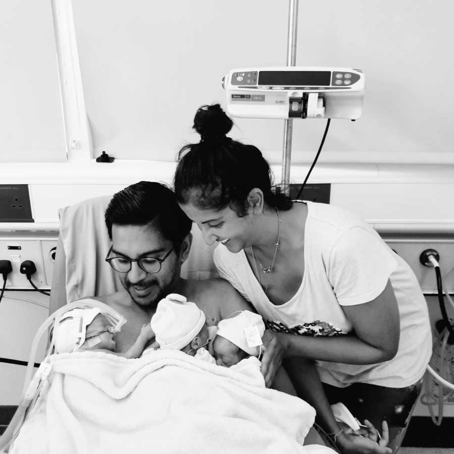 Intended parents hold their premature triplet sons after they get out of the NICU