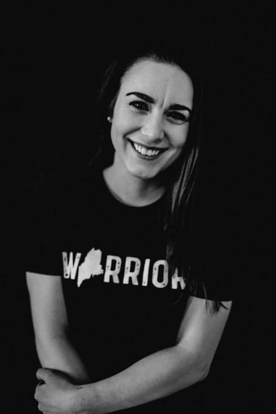 woman wearing a 'warrior' shirt smiling