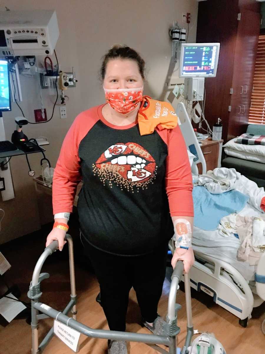 Woman recovering from post-covid pneumonia and a traumatic birth takes a photo walking in the hospital with a walker