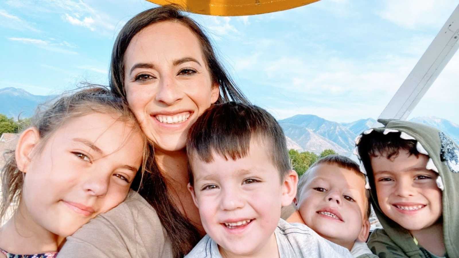 Widowed mom of 4 takes a selfie with her children with mountainous scenery behind them