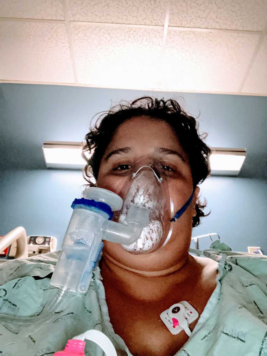 Woman who contracted COVID-19 takes a selfie in a hospital bed while breathing through a breathing machine