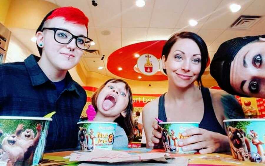 Autistic mom of 2 takes a selfie with her partner and her two children while they enjoy some fro-yo together