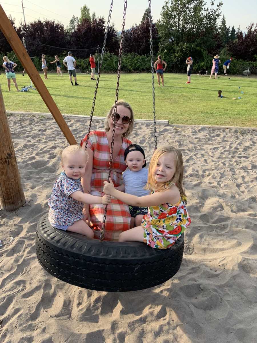 woman on a tire swing with her kids