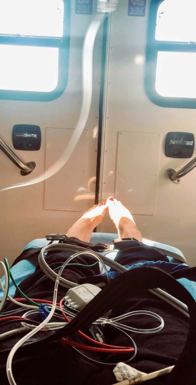 Woman suffering a severe panic attack from anxiety snaps a photo of her feet while laying down in an ambulance