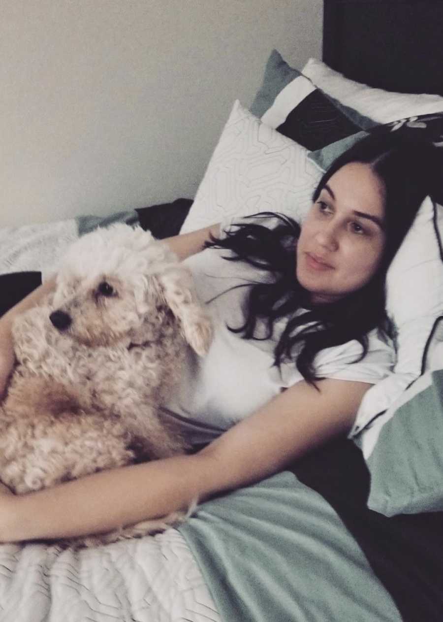 young woman in bed with her dog