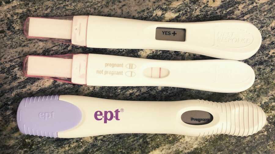 Three different positive pregnancy tests lined up next to each other