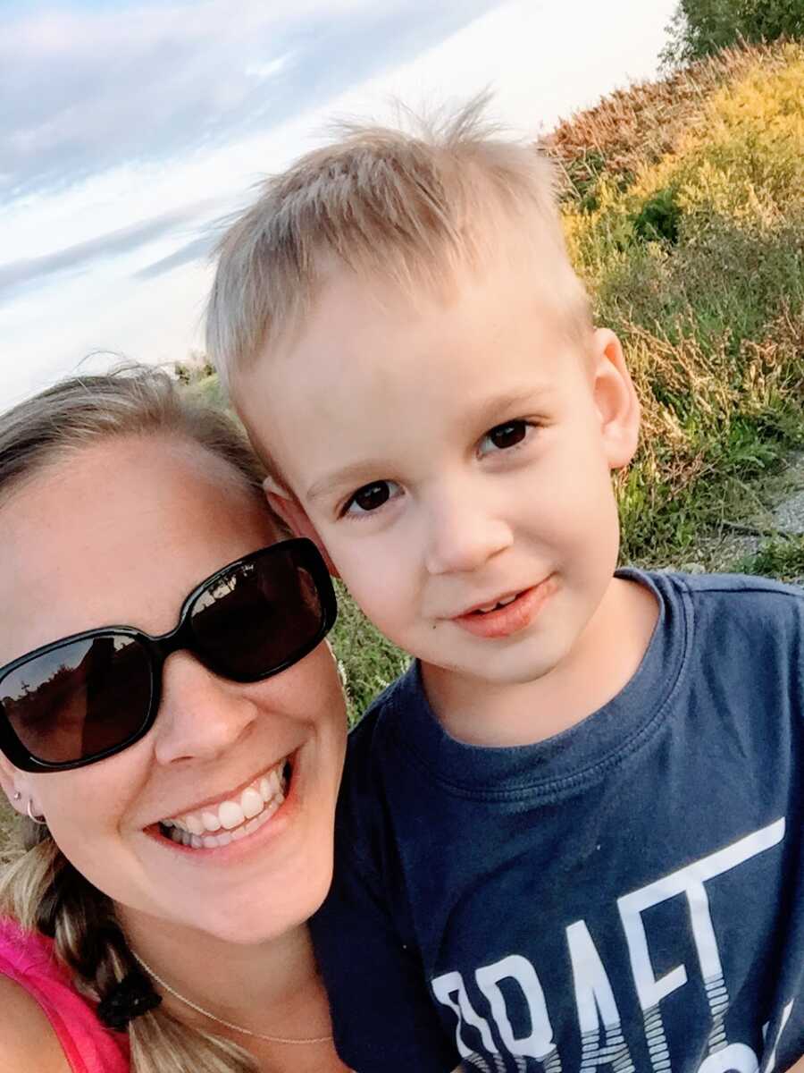 Mom of 3 takes a selfie with her middle child while on a walk through wheat fields