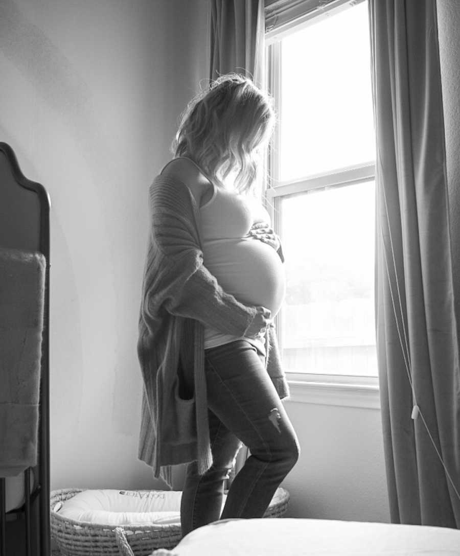 maternity photo of woman by a window