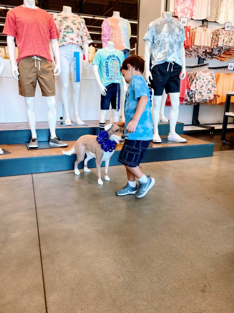 Little boy with autism pets the Old Navy Magic the mannequin dog during a shopping trip