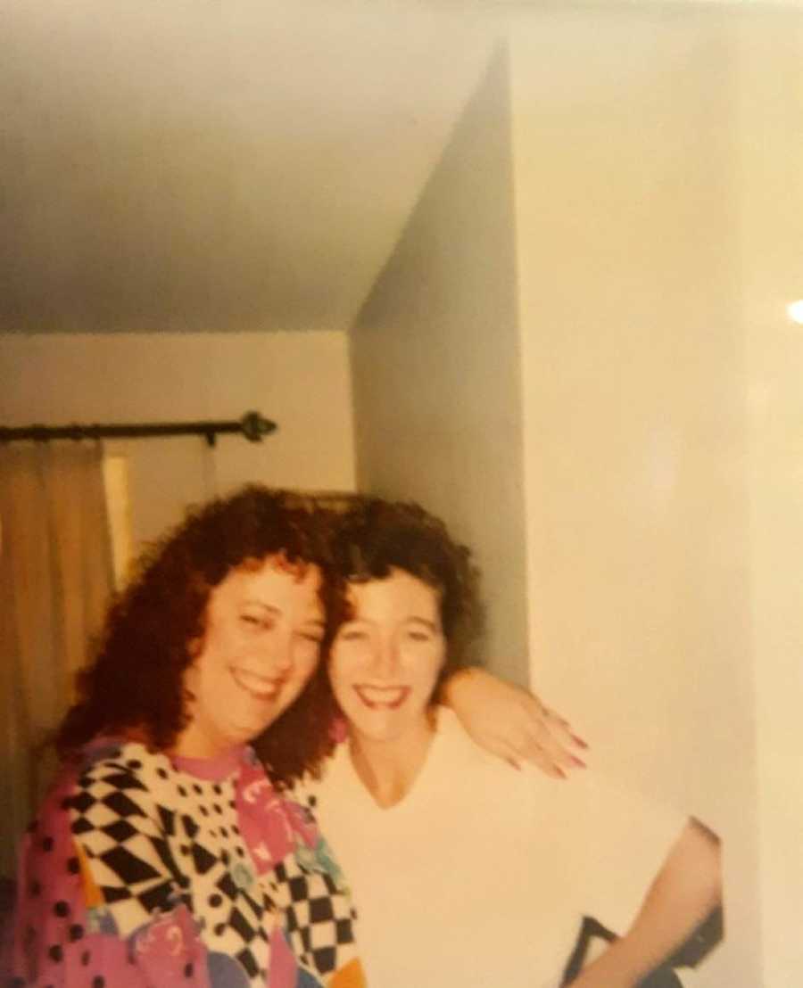 Young teen smiles and poses with her mom, decked out in 80's attire