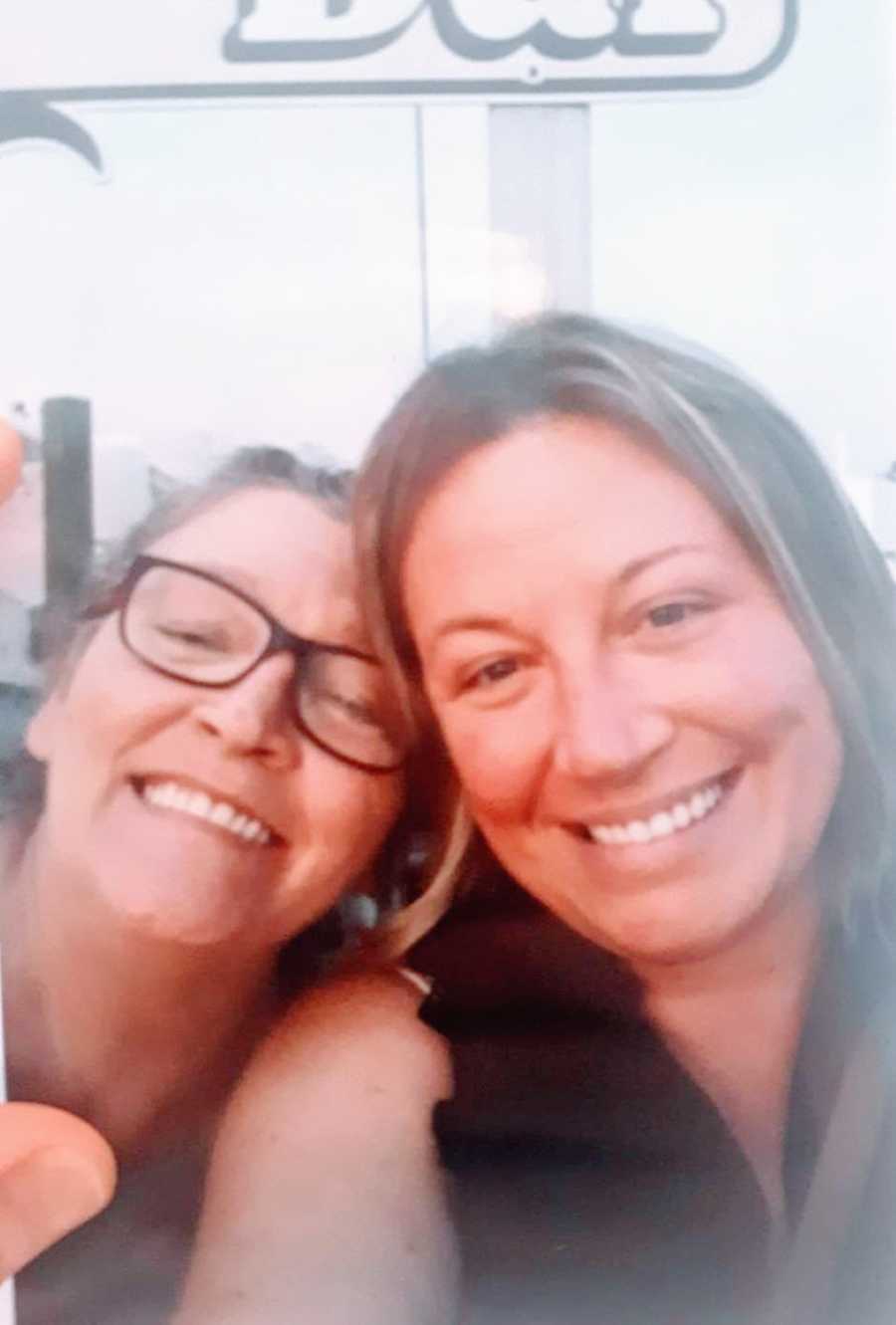 Mom and daughter smile while taking a polaroid at a birthday celebration