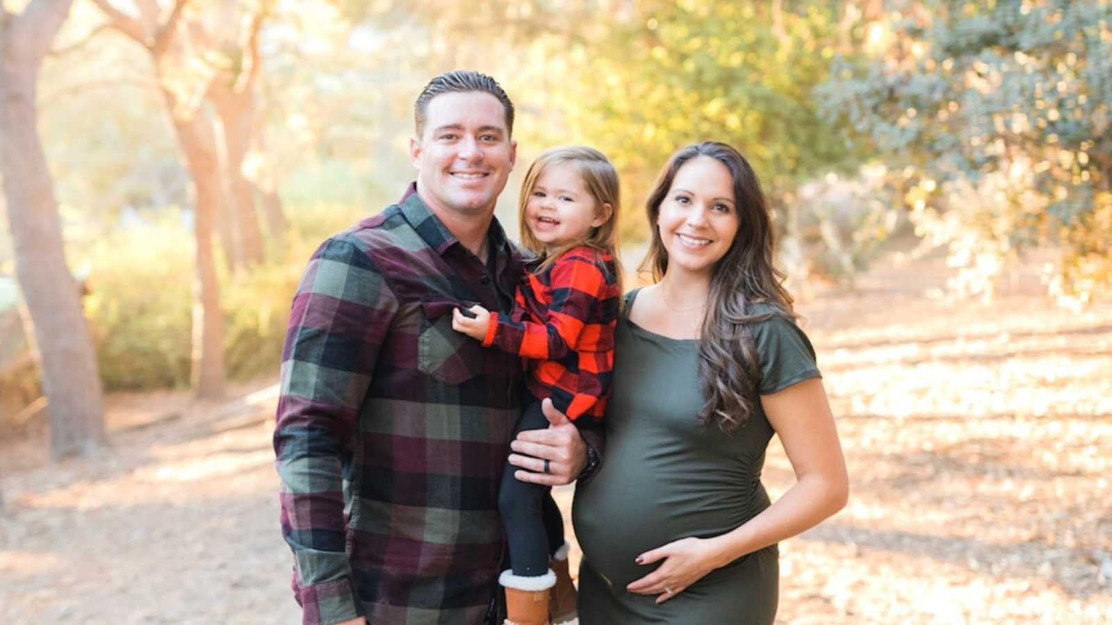 mom, dad, and daughter in fall clothes