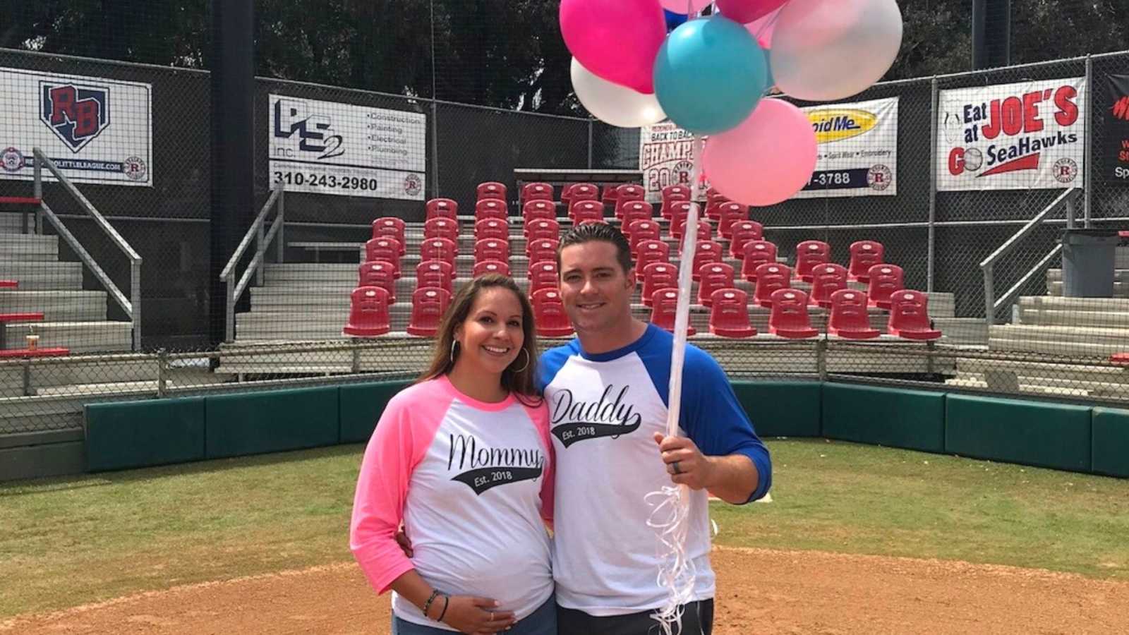pregnant mom and dad at baseball game with balloons