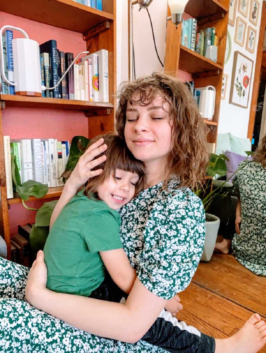 Woman hugs her son who wears a green shirt