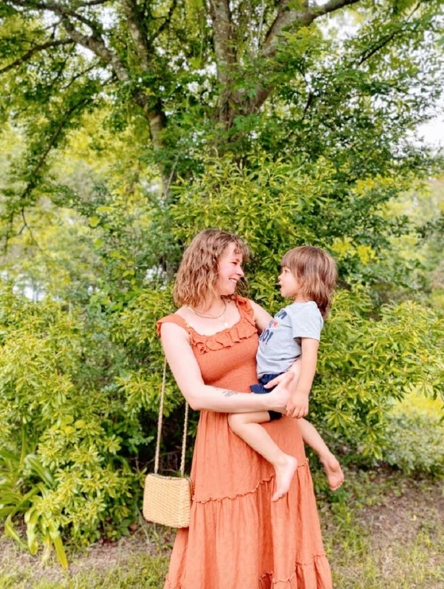 Mom holds her son outdoors