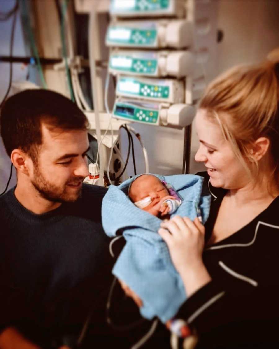 A woman and her partner with their newborn daughter