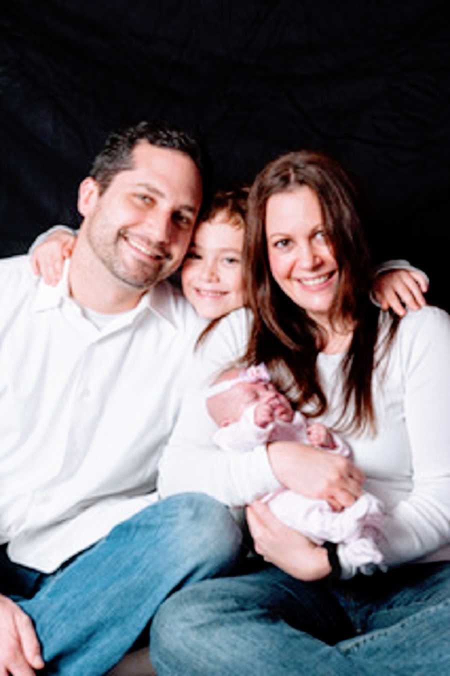 A family of four with their newborn baby girl