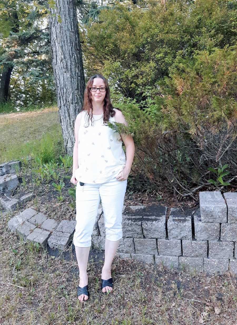 Woman wearing white stands outside