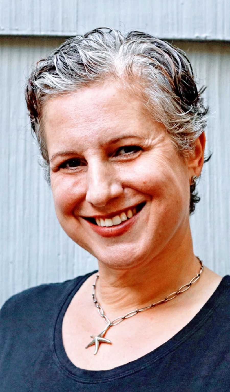 A woman in a black shirt with grey hair