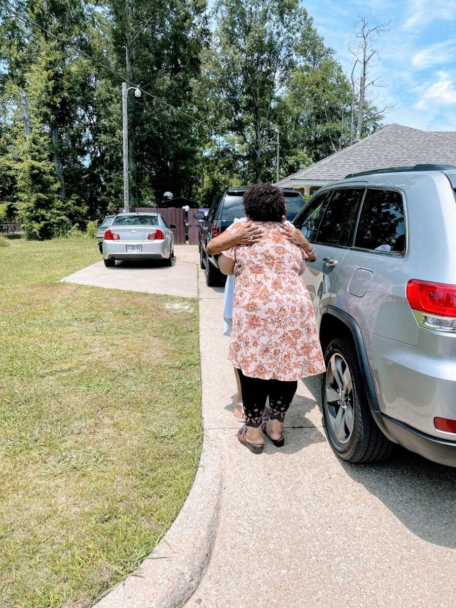 Adoptee hugs long lost biological sibling in driveway