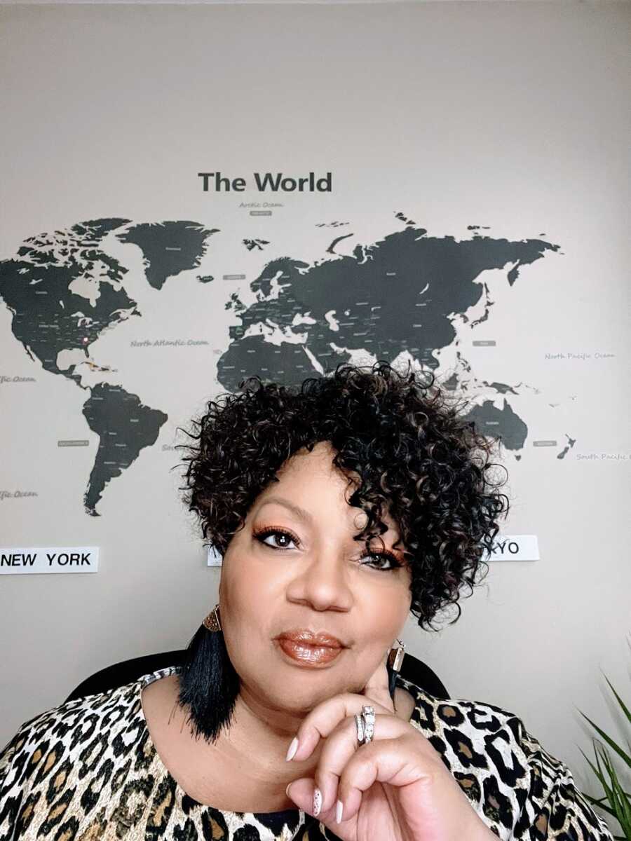 Adoptee sitting in front of map of the world