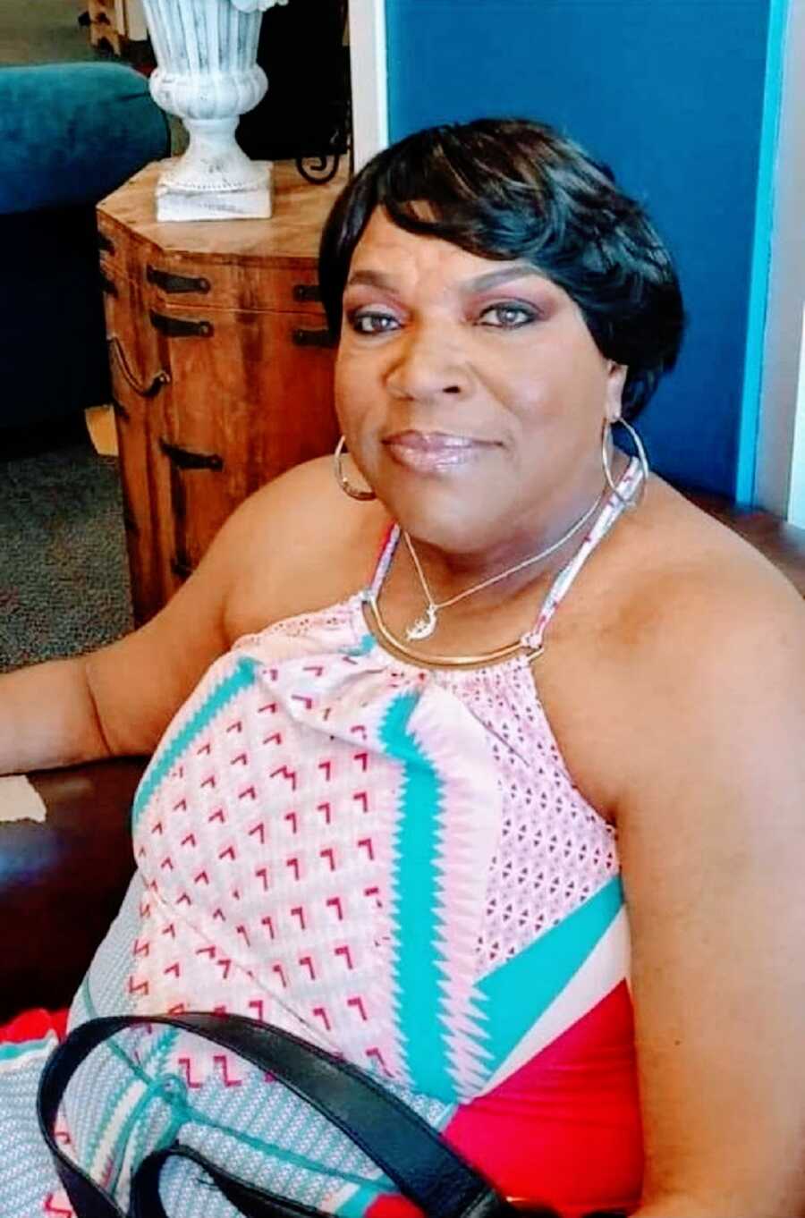 Woman seated wearing pink tank top