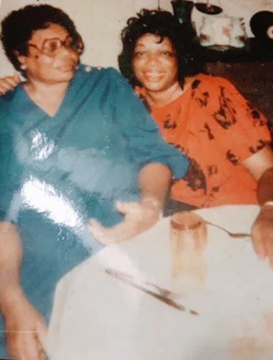 Two women sit together at table