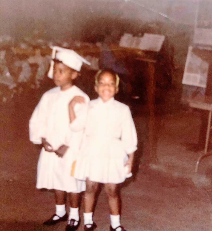 Two little girls dressed in caps and gowns for graduation