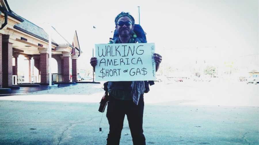 homeless man holding up a sign