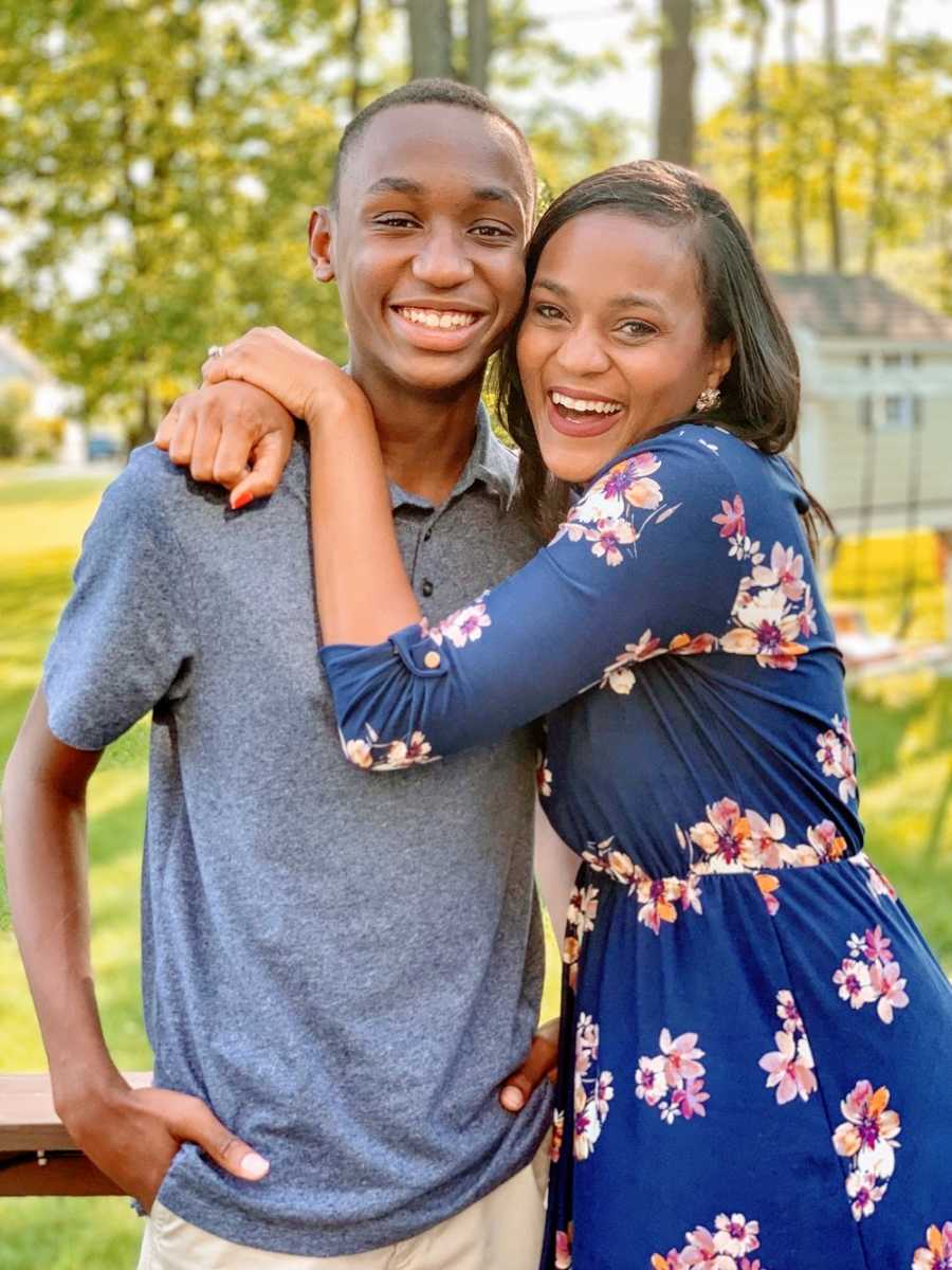 A mom hugs her teenage son around the neck