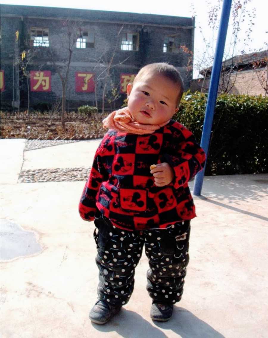 Little boy outside dressed in red coat