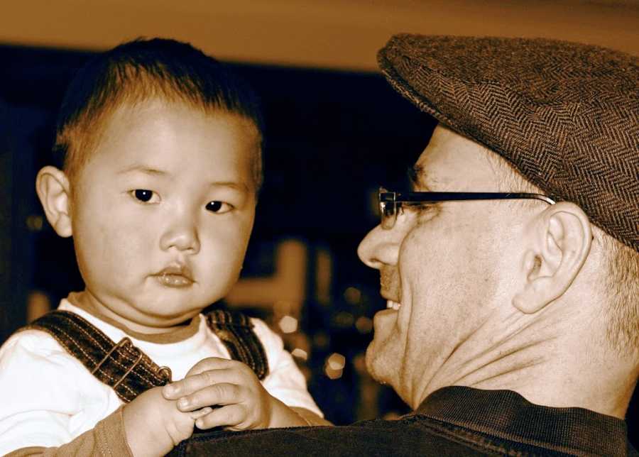 Father holds adoptive son from China