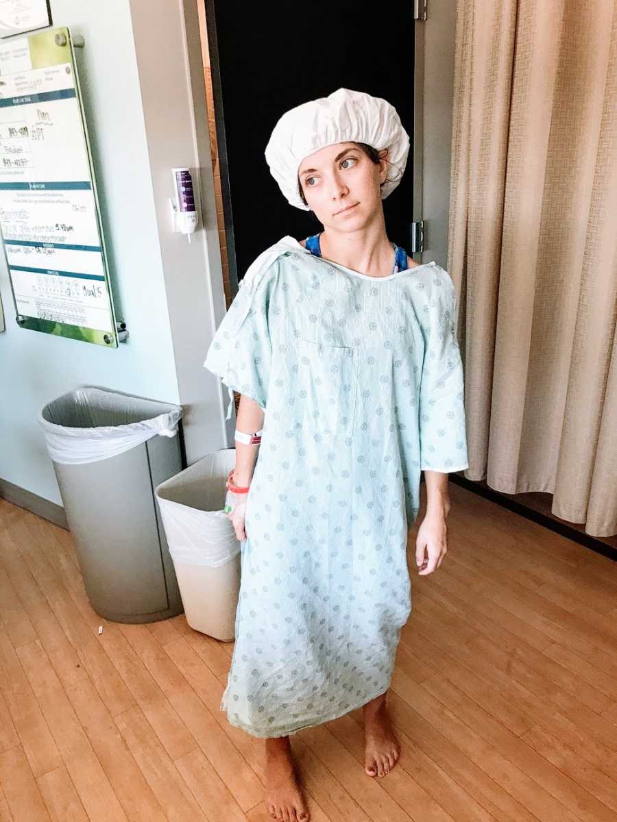 Woman in hospital gown standing alone