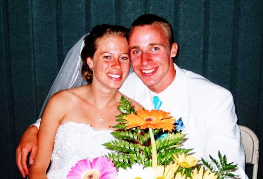 A bride and groom sit together at a wedding