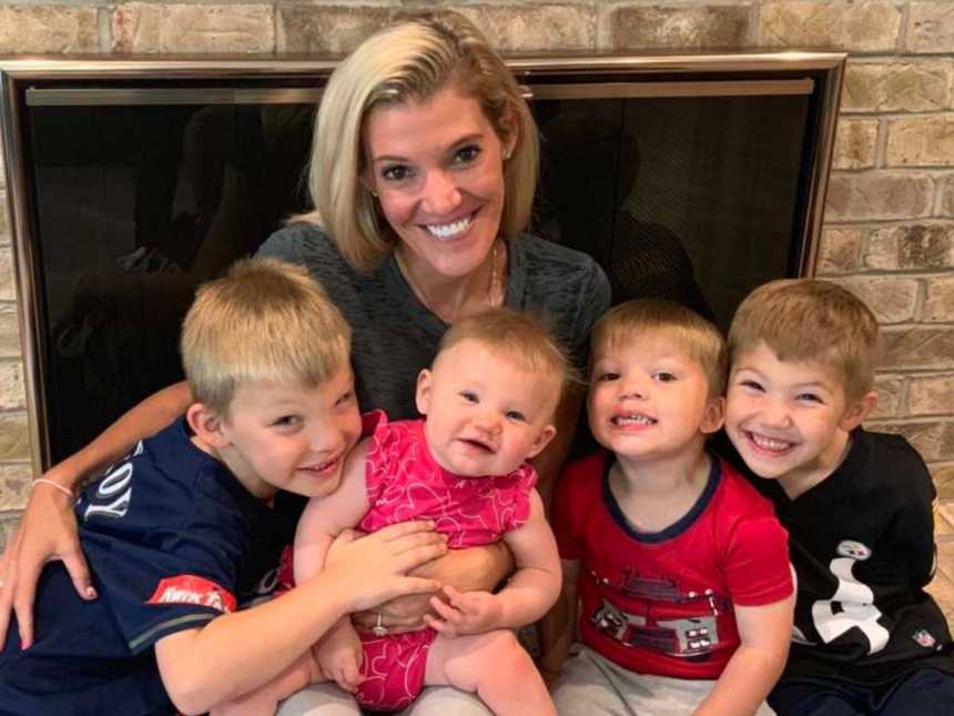 一位母亲和她的四个孩子坐在壁炉上