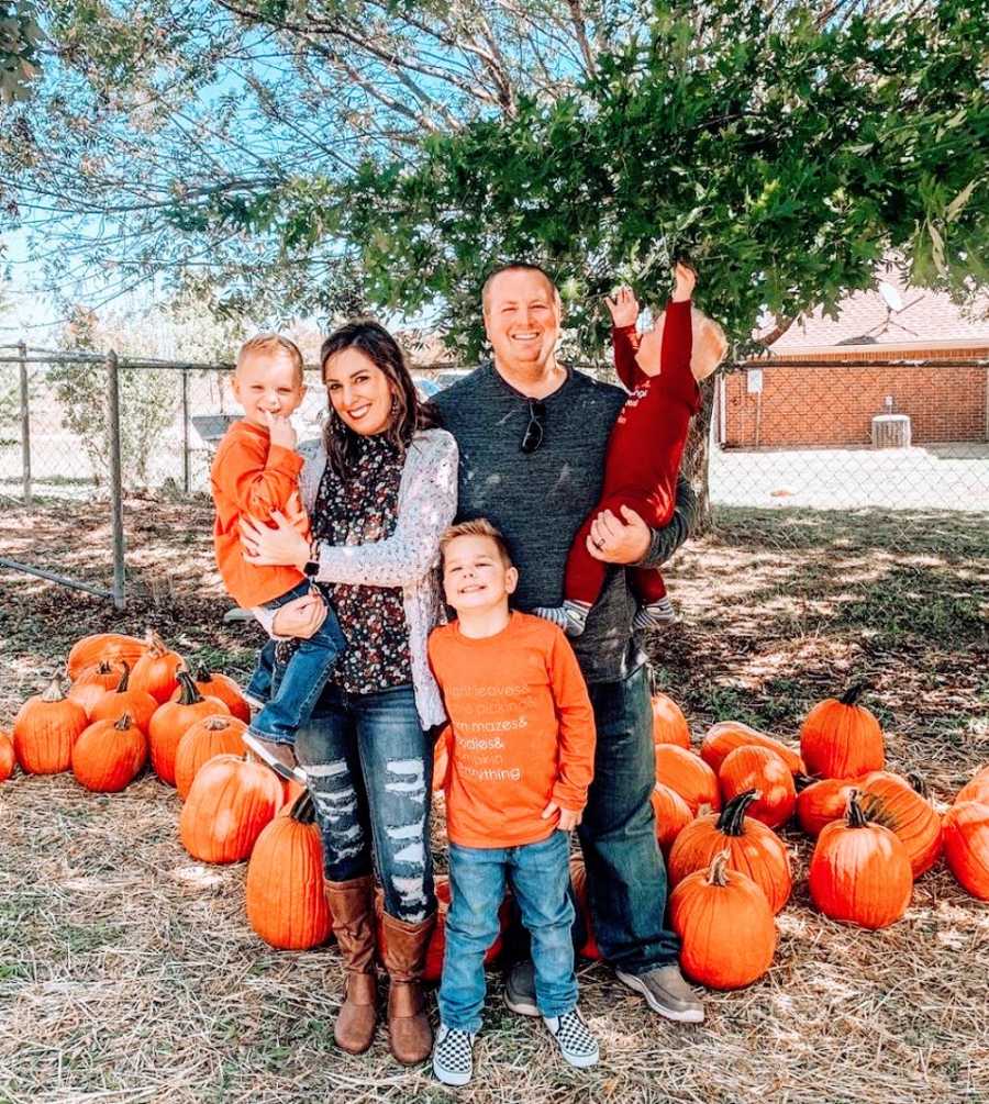 Parents hold their three children on Halloween