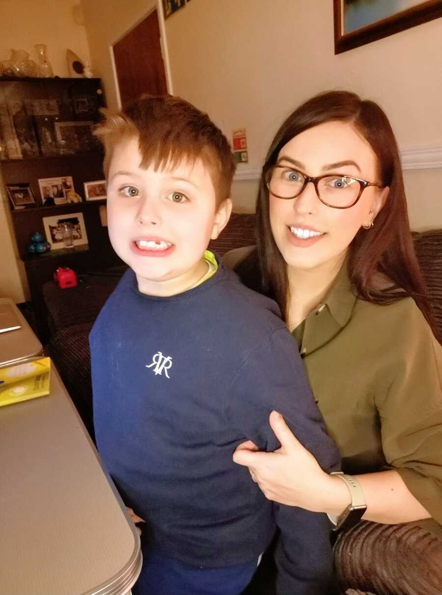 Boy in blue sweater sits on mom's lap