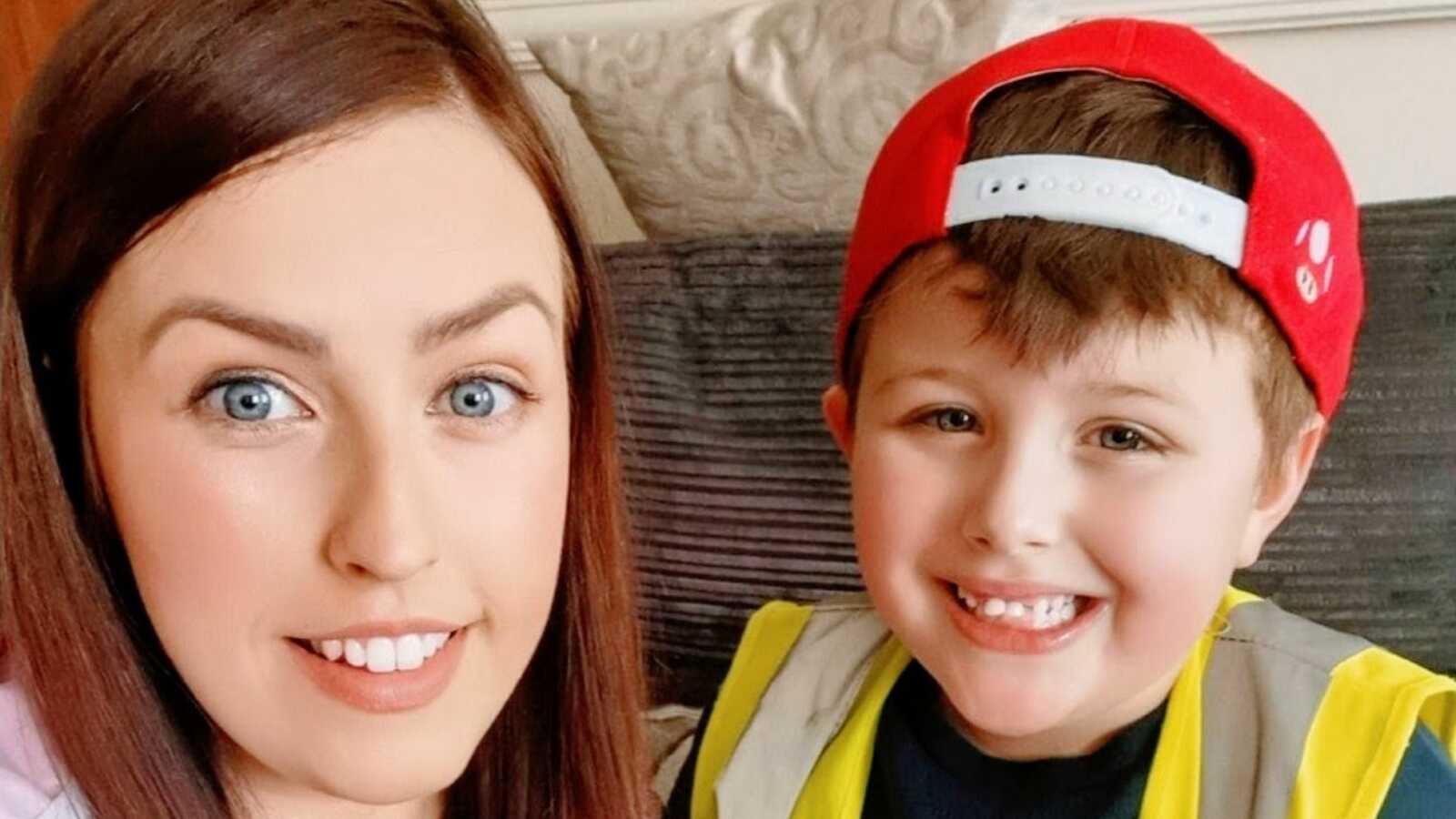 Mom and son with autism who is wearing red hat backwards