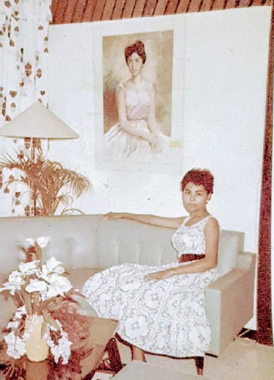 A young woman sits on a couch by herself