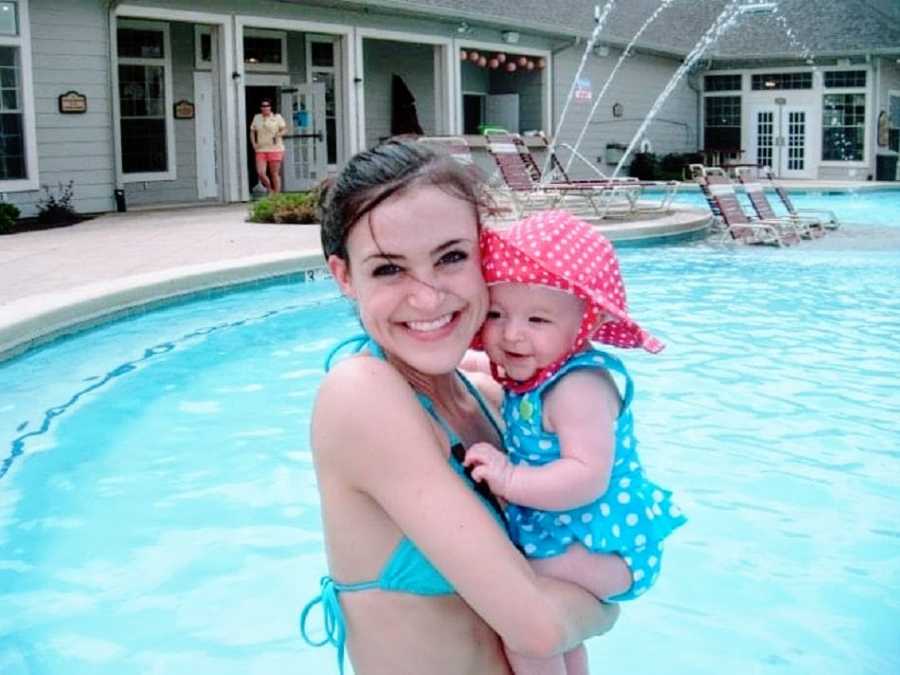 Mom holds baby girl in pool