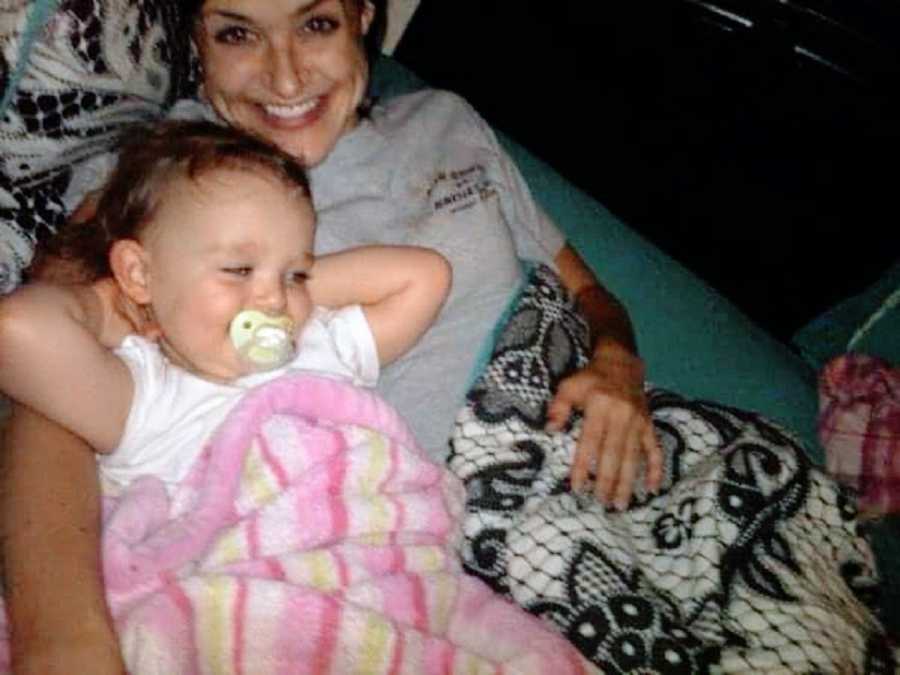 Mom and baby girl sit on couch together