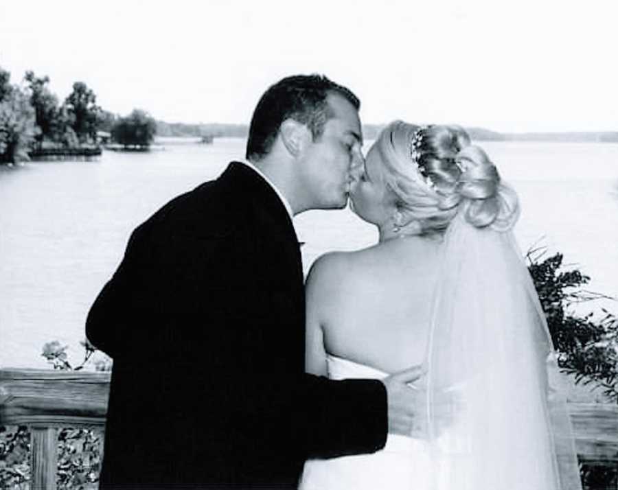 A woman and her husband kiss on their wedding anniversary