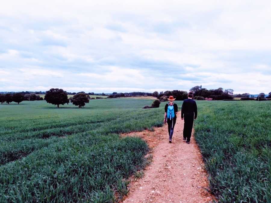 Two people walk together in a field