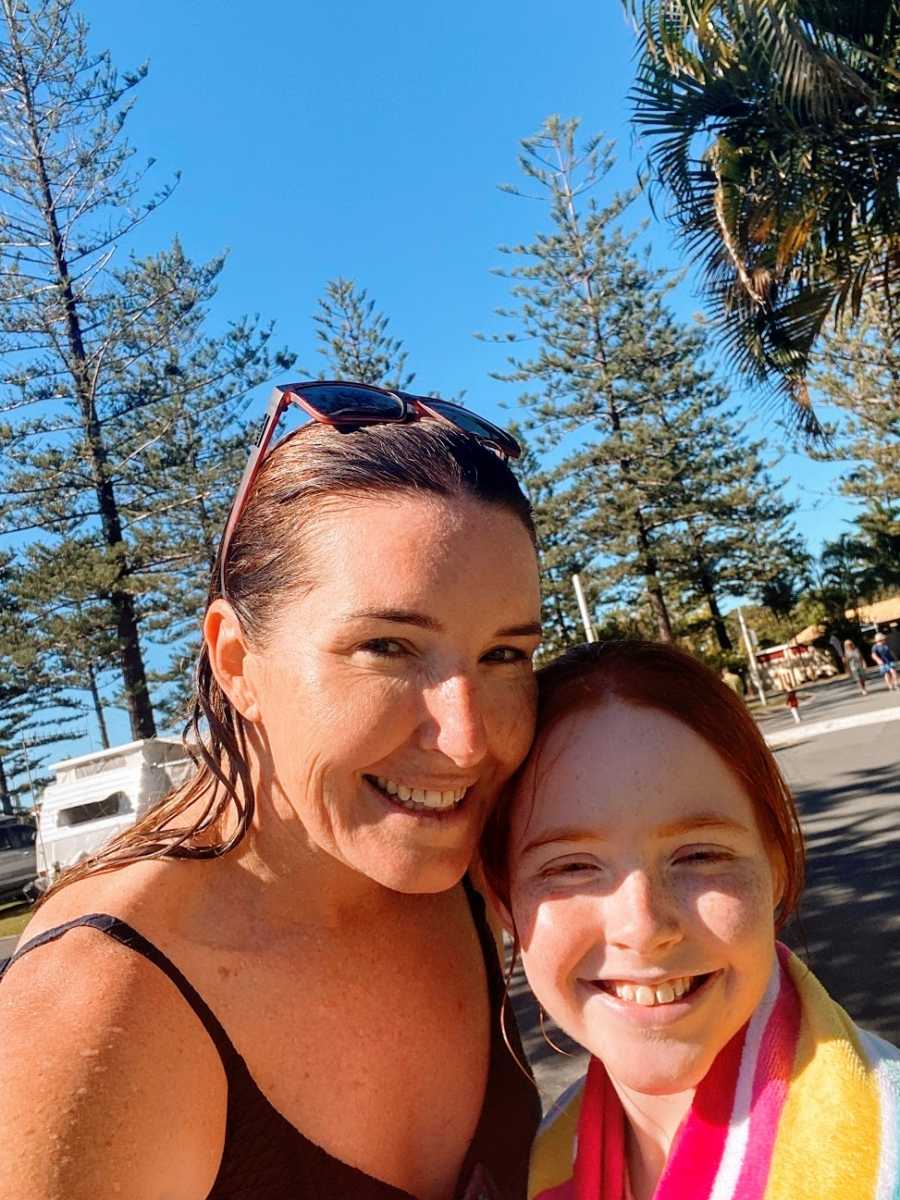 A mother and her daughter wearing swim clothes