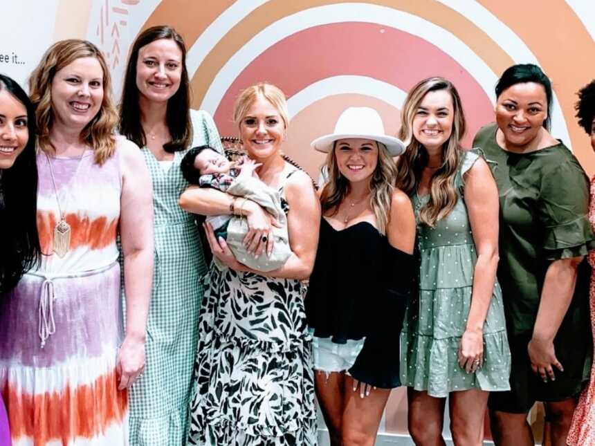 Woman battling unexplained infertility takes a photo with her faith-based infertility support group