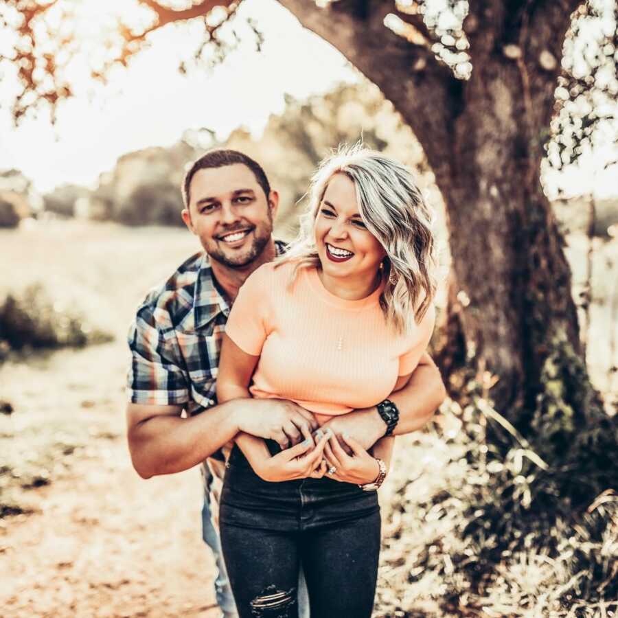 Couple struggling with unexplained infertility take a candid photo together while holding hands