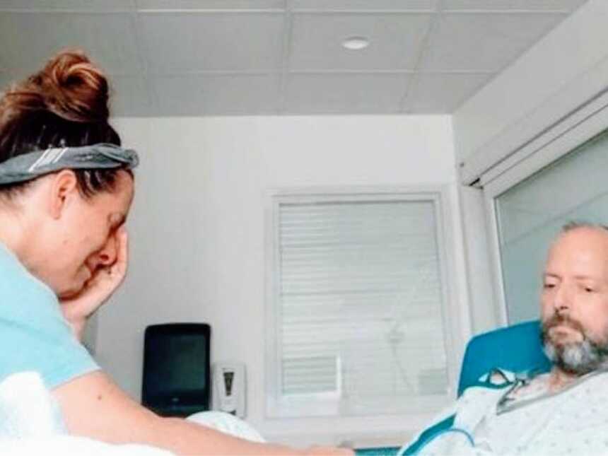 一位妇女在临终关怀中心为身患晚期癌症的丈夫哭泣