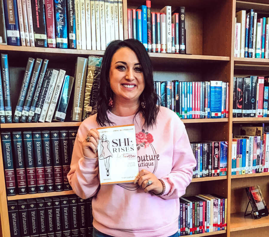 Mom holding a book she collaborated on and published