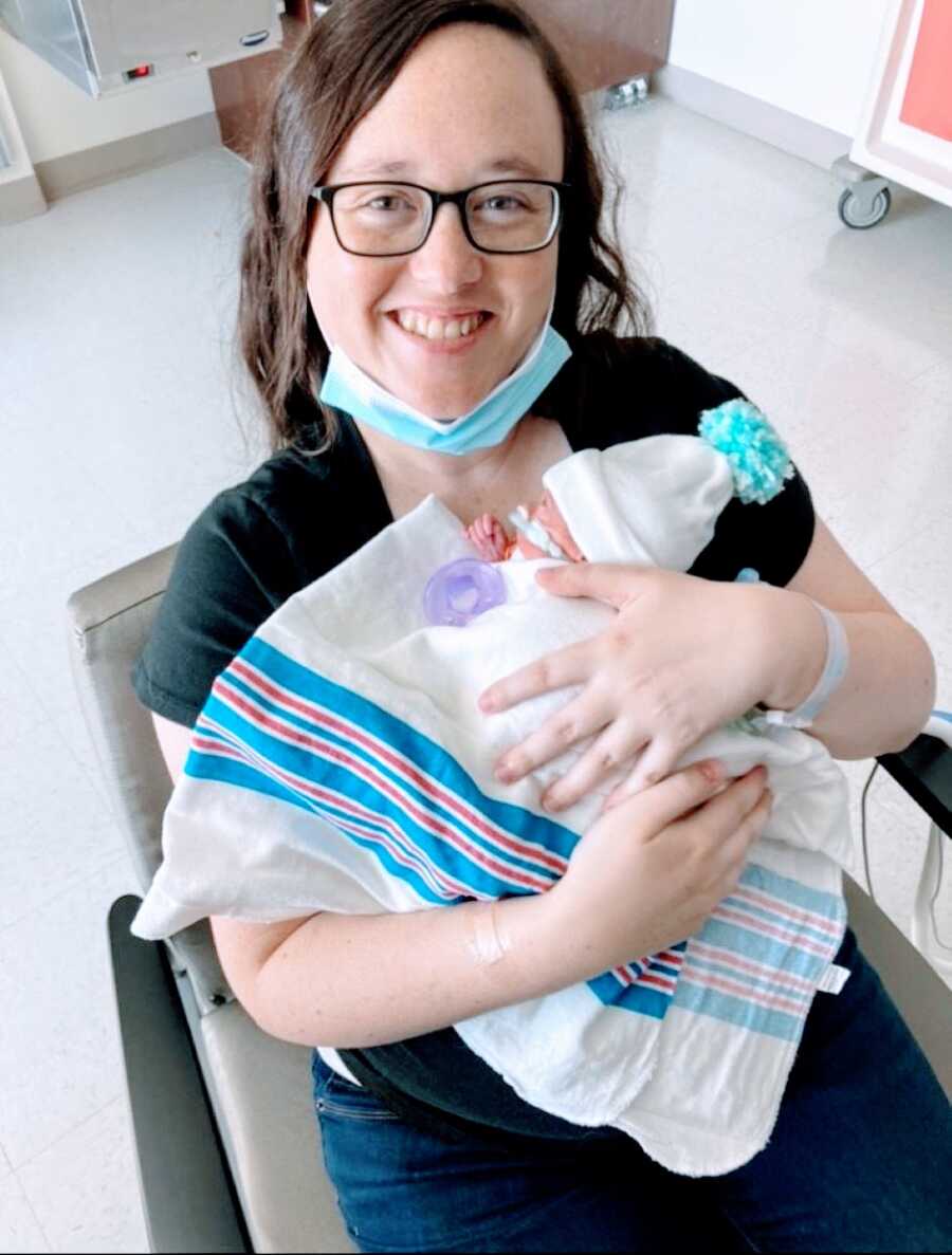 妈妈第一次抱着她的一个双胞胎女儿，是在她出生后12天，通过紧急剖腹产